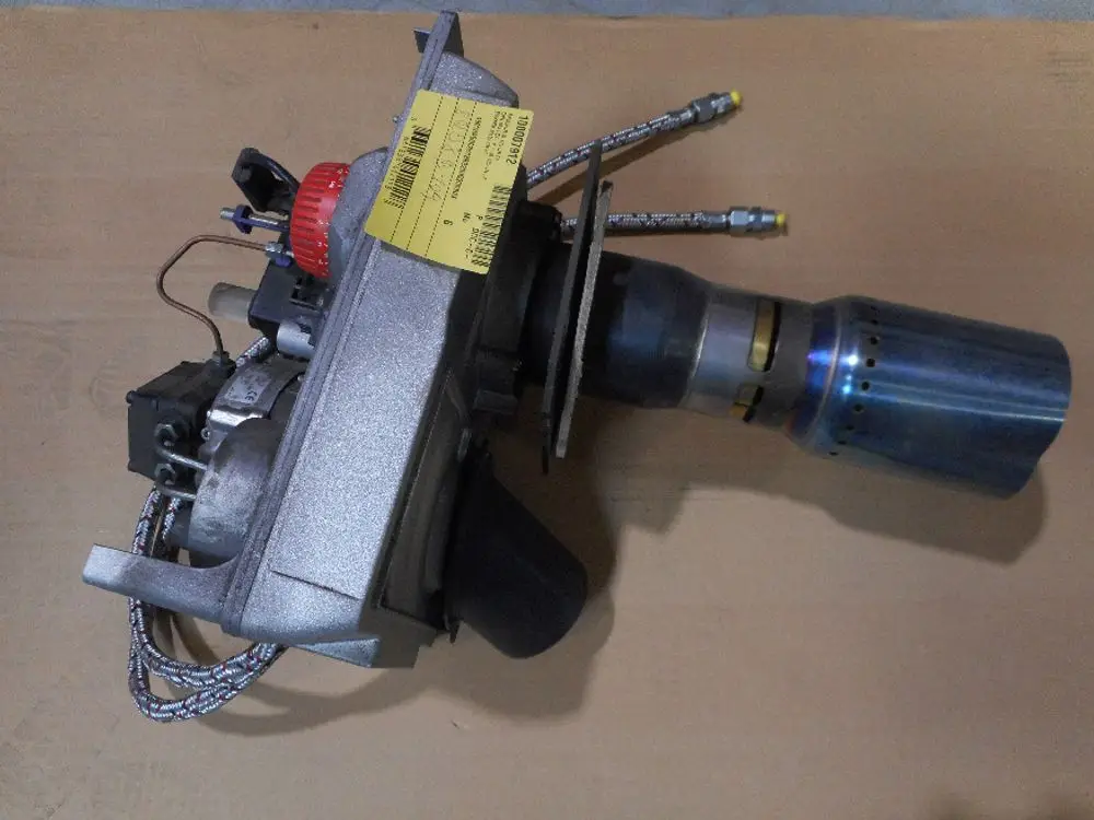 Remeha Heizgerät mit mehreren Komponenten, darunter ein Motor, Rohrleitungen und eine Auspufföffnung aus Metall, auf einer flachen Unterlage platziert.